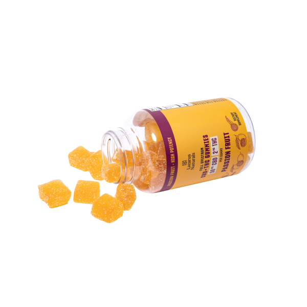 A bottle of vitamin D3 gummies spilling out on a white background.